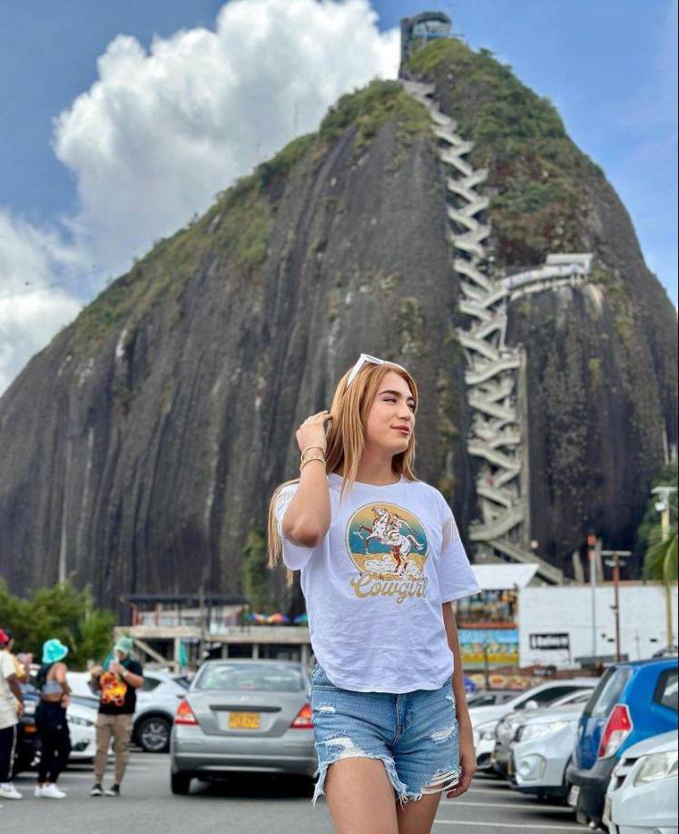 Luciendo su cabello largo,un short y una camisa blanca. 