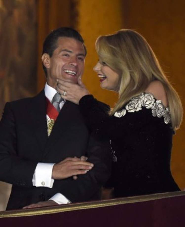Mexican President Enrique Pena Nieto speaks with his wife the First Lady Angelica Rivera on the main balcony of the National Palace during ceremonies called 'The Shout' marking the start of celebrations of Independence Day in Mexico City on September 16, 2017. / AFP PHOTO / ALFREDO ESTRELLA