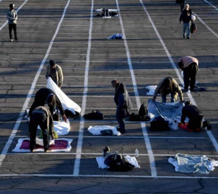 Las personas llegan a un refugio temporal para personas sin hogar establecido en un estacionamiento en el Cashman Center el 30 de marzo de 2020 en Las Vegas, Nevada. Catholic Charities of Southern Nevada se cerró la semana pasada después de que un hombre sin hogar que utilizó sus servicios dio positivo por el coronavirus, dejando a unas 500 personas sin refugio durante la noche. <br/>