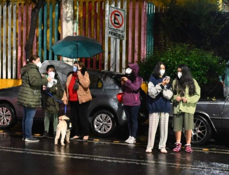 "People remain outside their houses after a quake in Mexico City, on September 7, 2021. - A 6.9 magnitude earthquake struck Mexico on Tuesday near the Pacific coast, the National Seismological Service said, shaking buildings in the capital. (Photo by RODRIGO ARANGUA / AFP)"