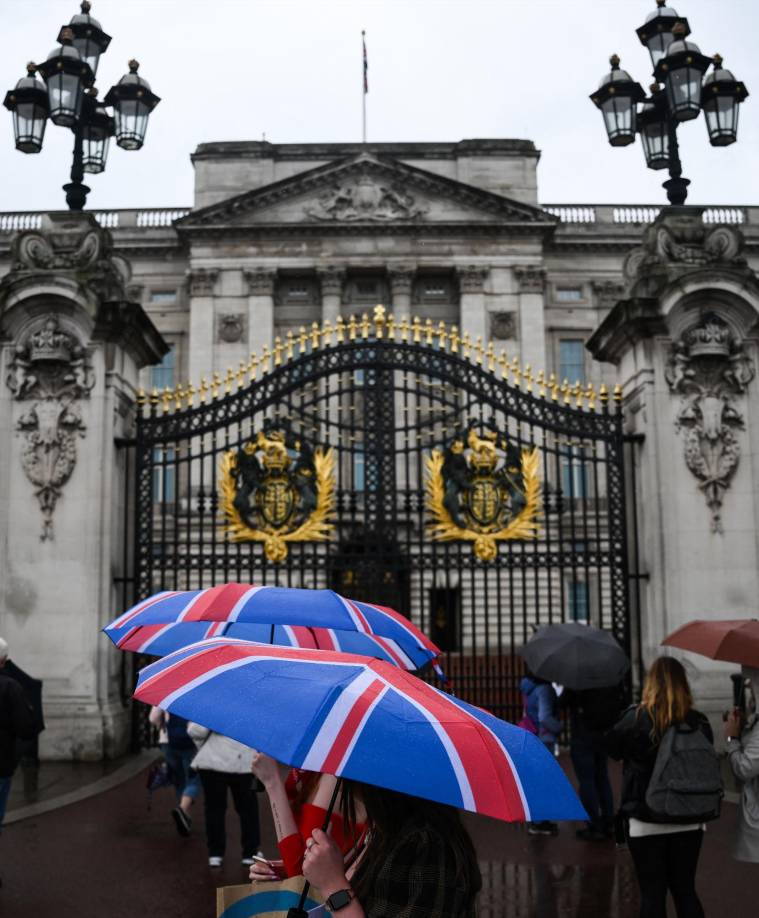 Decenas de británicos o turistas se concentraron bajo la lluvia para compartir su preocupación y sus emociones ante el palacio londinense.