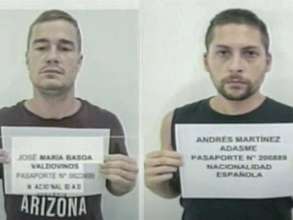 Los ciudadanos españoles José María Basoa(i) y Andrés Martínez Adasne (d) sosteniendo una hoja con sus datos de identificación, tras ser detenidos en Venezuela.