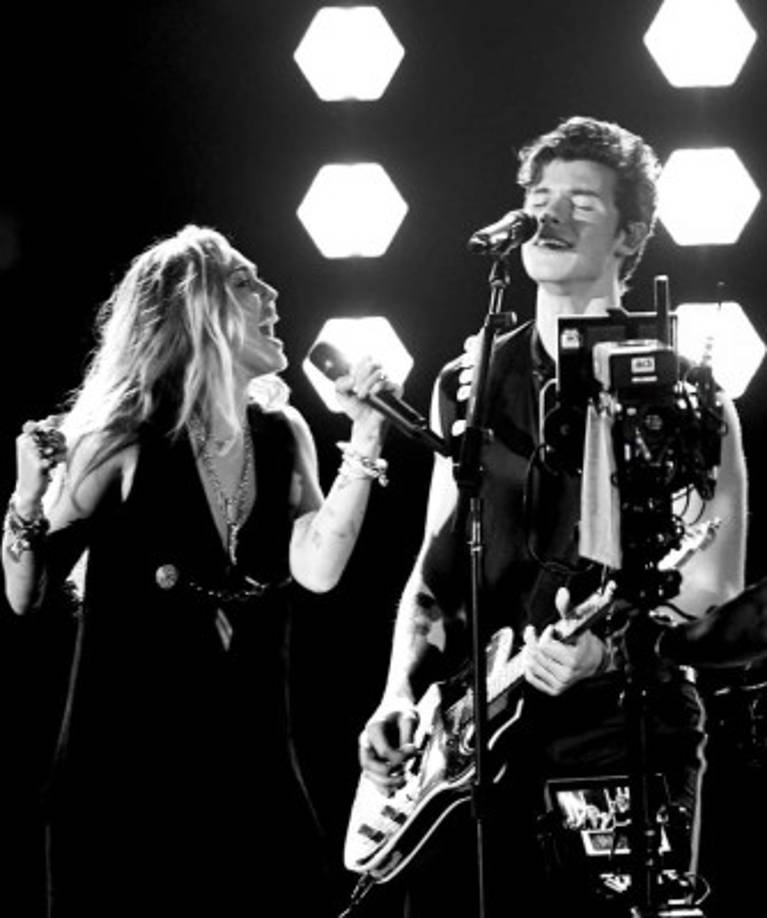 Este look logró mezclar elegancia, sensualidad con un toque de country. Lo rematan unas botas negras, cerradas, en taco aguja. También lleva unos colgantes dorados que adornan su pecho.<br/><br/>Este conjunto pertenece a la firma Saint Laurent.<br/><br/>