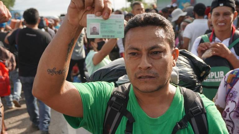 Un migrante centroamericano muestra una tarjeta de identificación ofrecida por el Instituto Nacional de Migración (INM) hoy, en el municipio de Jesús Carranza, Veracruz .