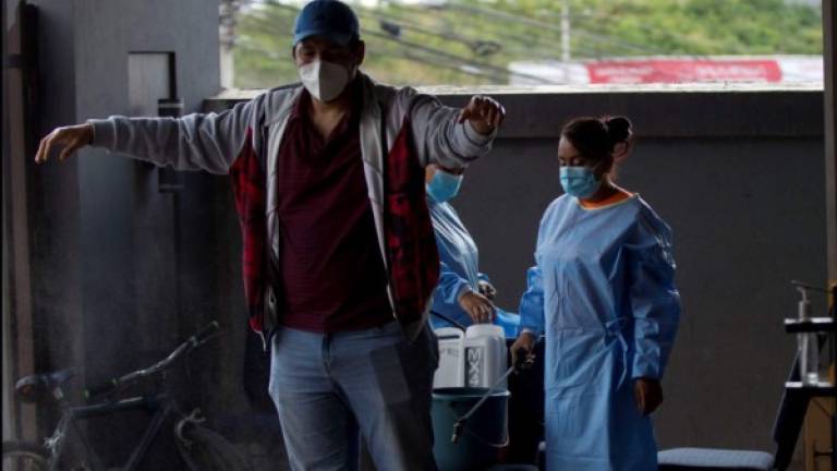 Un miembro del personal de salud desinfecta a un hombre en un centro para la detección de la nueva variante del coronavirus hoy, en Tegucigalpa (Honduras). EFE