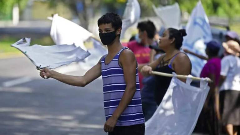 Con banderas blancas o rojas miles de personas claman por alimentos en Centroamérica./AFP.