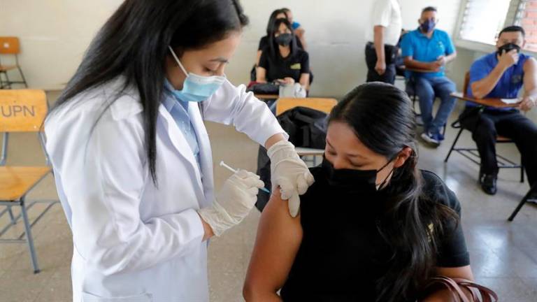Una trabajadora de la salud vacuna a una mujer contra el coronavirus en Tegucigalpa.
