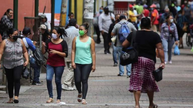 Mujeres con tapabocas caminan este miércoles en la Calle Peatonal de Tegucigalpa (Honduras).