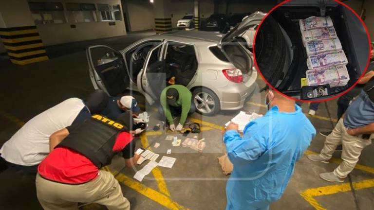 Especialistas inspeccionando el vehículo donde se halló el dinero.