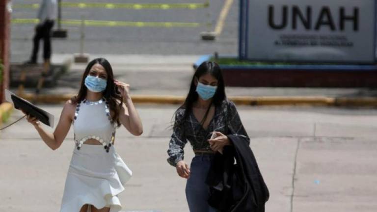 Dos jóvenes universitarias salen de la graduación tras la entrega del titulo en la Universidad Nacional Autónoma de Honduras este miércoles, en Tegucigalpa (Honduras).