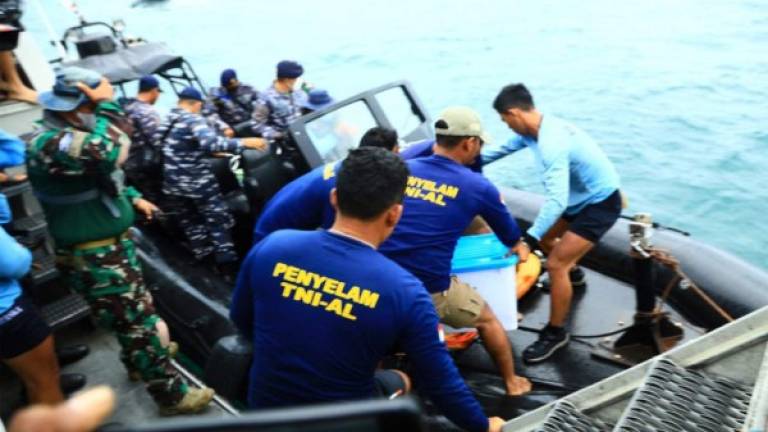 El equipo de buzos de la Armada que recuperó la grabadora de datos de vuelo, regresó al barco desde el lugar del accidente frente a la costa de Yakarta. Foto AFP