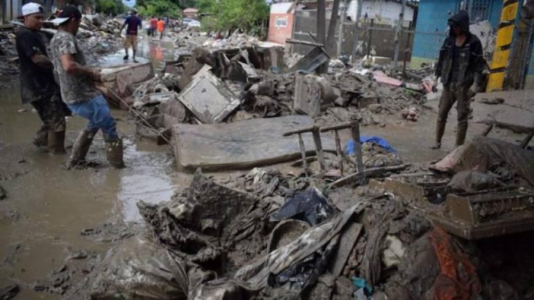 Personas retornan hoy a sus viviendas para retirar los escombros tras las inundaciones que dejó a su paso Iota, en la localidad de La Lima, departamento de Cortés (Honduras).