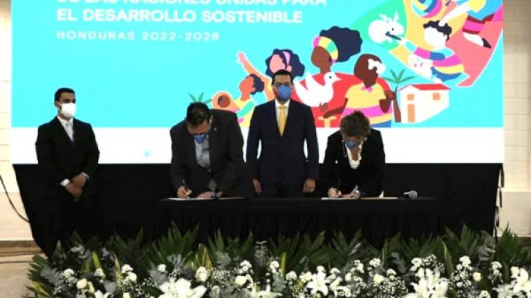 Representantes del Gobierno de Honduras y de Naciones Unidas firmando el acuerdo.