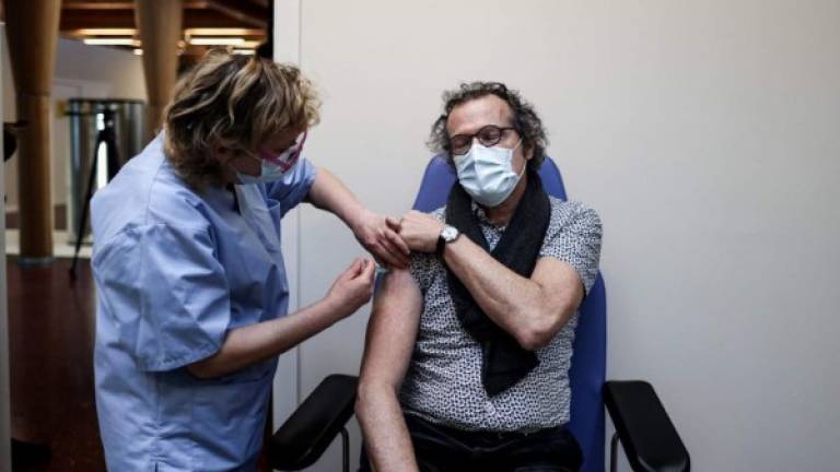 Un hombre es vacunado con una inyección de Moderna en un centro de Bélgica. Foto AFP