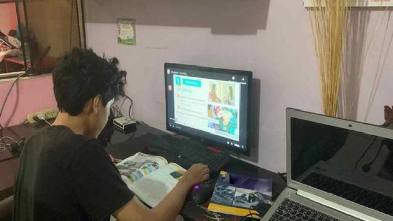Imagen de referencia de niño trabajando en computadora.