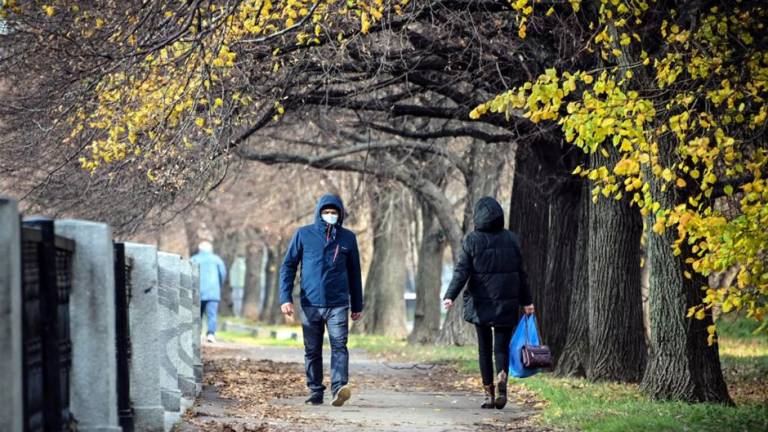 Un hombre con una máscara facial camina en un parque en el oeste de Moscú.