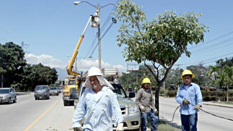 Empleados de la estatal eléctrica supervisan trabajos de mantenimiento en el bulevar del norte de San Pedro Sula. Foto: Amílcar Izaguirre