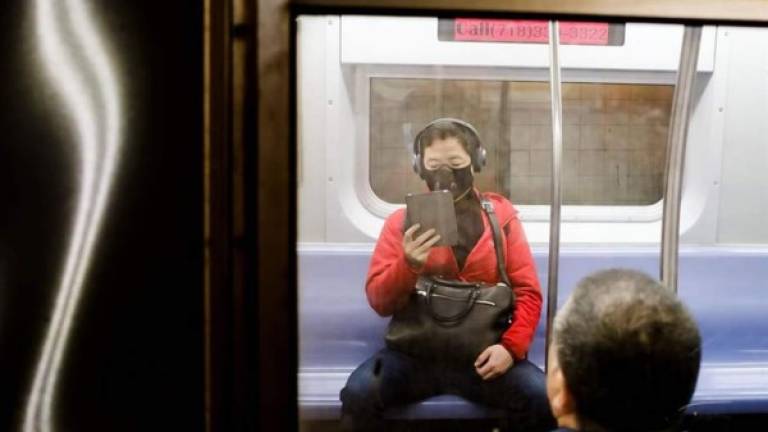 Una persona con una máscara facial viaja en un tren subterráneo en Nueva York, Nueva York, Estados Unidos. EFE