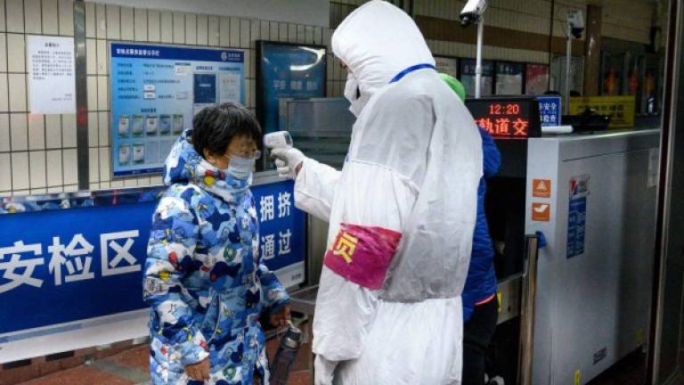 Autoridades sanitarias de Beijing realizan controles en las estaciones de tren y buses para evitar más contagios de coronavirus./AFP.