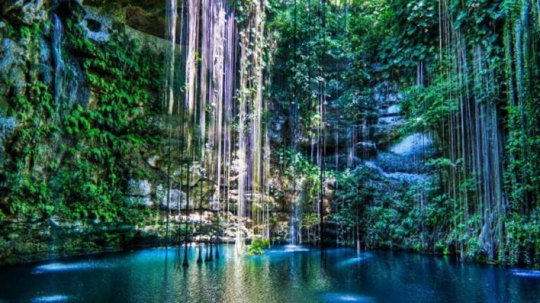 El majestuoso cenote de Ik Kil en Chichén Itzá es conocido como una de las piscinas naturales con agua azul pura. Se encuentra ubicado en el norte de la Península de Yucatán, México.