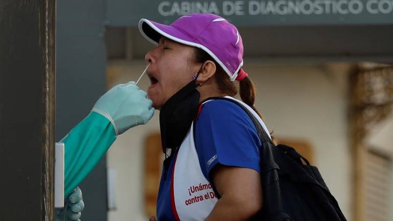 Una mujer se realiza una prueba de PCR para detectar el COVID-19 en una cabina del ministerio de salud ubicada afuera del Teatro Nacional, hoy en San Salvador (El Salvador).