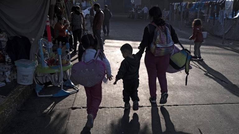 Una familia llega a un improvisado campamento de migrantes en Tijuana. EEUU inició hoy a devolver los solicitantes de asilo a México.