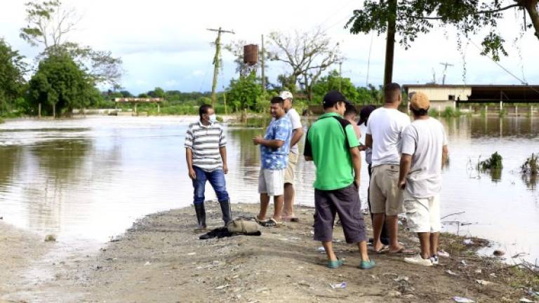 La entrada principal a los bajos de Choloma, donde hay cerca de 40 aldeas, permanece inundada y hay muchas corrientes con la fuerza para arrastrar carros. Por el sector de Ticamaya también está inundado. Fotos: Moisés Valenzuela