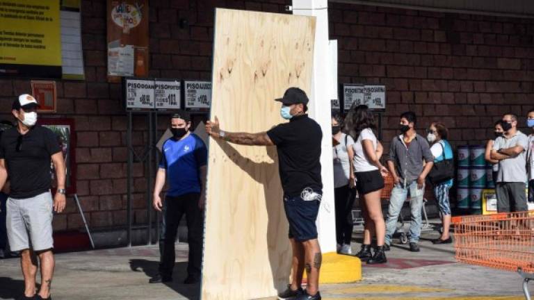 Locals buy boards to protect their homes in preparation for the arrival of Delta Huracan in Cancun, Quintana Roo state, Mexico on October 6, 2020. - Hurricane Delta intensified into a Category 3 storm on Tuesday and is set to slam into Mexico's Yucatan Peninsula early on Wednesday, the US National Hurricane Center said. (Photo by ELIZABETH RUIZ / AFP)