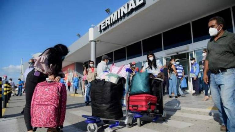 Pasajeros hondureños del vuelo humanitario procedente de Madrid (España) llegan este martes, al aeropuerto Ramón Villeda Morales. EFE