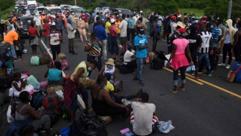 Members of a caravan of migrants from DR Congo, Ghana and Ivory Coast block the Pan-American highway after being stopped by agents of the Honduran National Police near Choluteca, as they were heading to Tegucigalpa to make a stop on their way to Mexico, in Honduras on June 2, 2020 amid the Covid-19 coronavirus pandemic. (Photo by ORLANDO SIERRA / AFP)