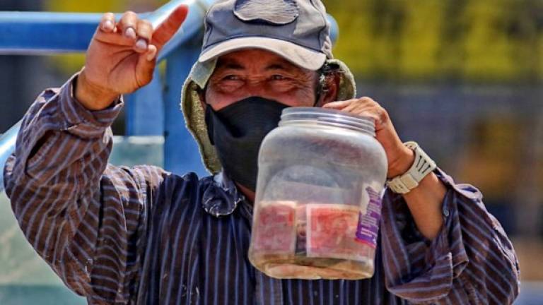Un adulto mayor pide dinero en una calle este jueves, en Tegucigalpa.