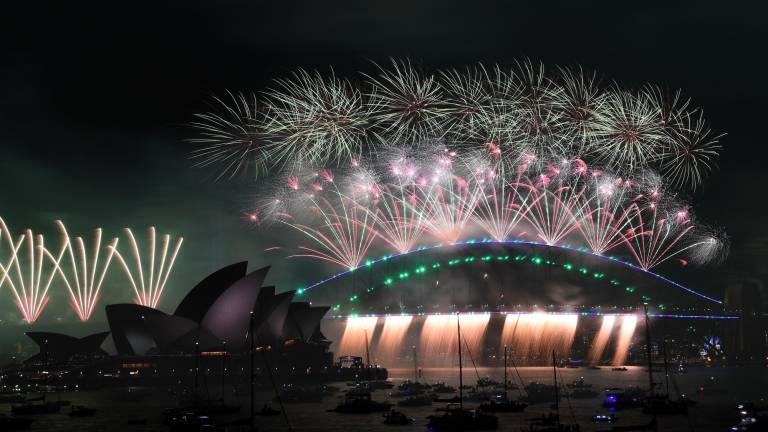 Los fuegos artificiales de medianoche se ven sobre la Ópera de Sydney y el Sydney Harbour Bridge durante las celebraciones de Nochevieja en Sydney
