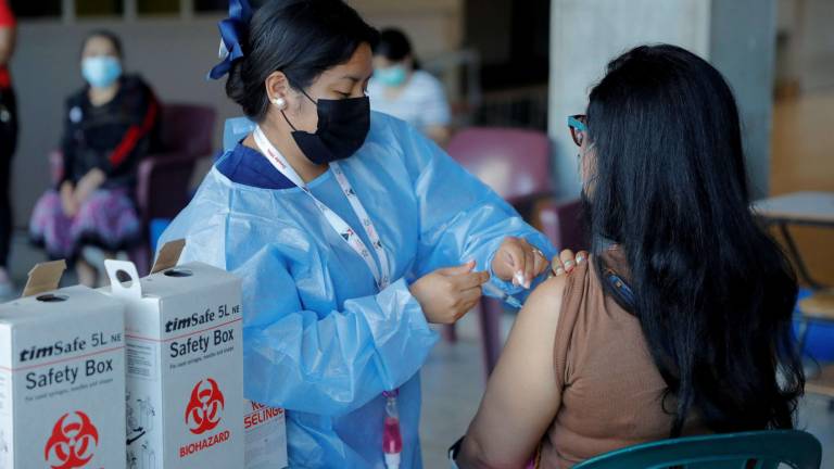 Una enfermera aplica una dosis de vacuna a una mujer en San Pedro Sula.