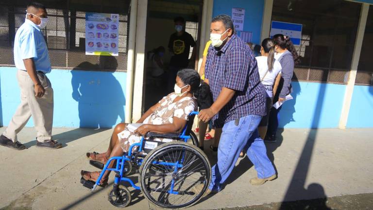 Acompañada de su hijo quién empuja su silla de ruedas, Reina Isabel Valeriano de 60 años ejerció el sufragio en el Centro de Educación Básica Gubernamental José Antonio Peraza del sector Rivera Hernández.