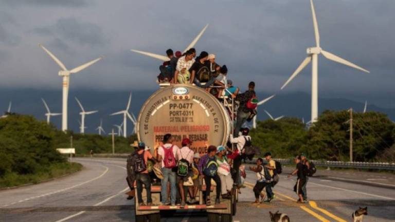(FILES) In this file photo taken on October 30, 2018 a truck carrying mostly Honduran migrants taking part in a caravan heading to the US, passes by a wind farm on their way from Santiago Niltepec to Juchitan, near the town of La Blanca in Oaxaca State, Mexico. - The Trump administration announced December 20, 2018 that it will send migrants who cross the southern border back to Mexico while their cases are being heard so they cannot 'disappear' on US soil. 'Aliens trying to game the system to get into our country illegally will no longer be able to disappear into the United States, where many skip their court dates,' announced Homeland Security Secretary Kirstjen Nielsen. (Photo by GUILLERMO ARIAS / AFP)