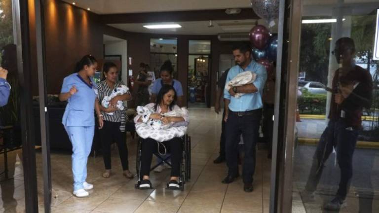 Los padres de los niños y otros familiares salen del hospital cargando a los bebés, mientras los acompaña personal médico que los asistió desde el sábado. Fotos: Moisés Valenzuela