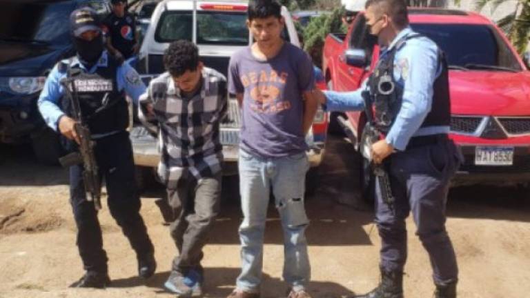 Dos de los detenidos son resguardados por agentes de la Policía de Comayagua.