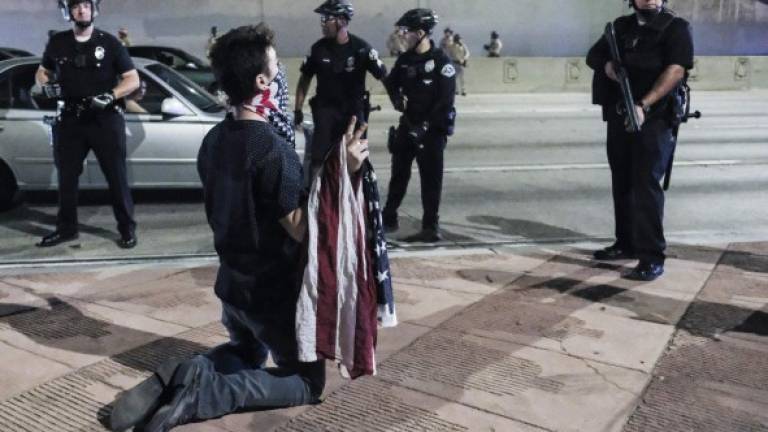 Un ciudadano inconforme con el resultado de las elecciones es abordado por la policía en Los Ángeles. Foto: AFP