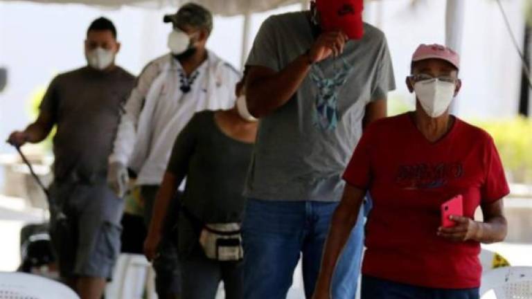Personas esperan para ser atendidas en un centro de triaje para el nuevo coronavirus este lunes en Tegucigalpa. EFE