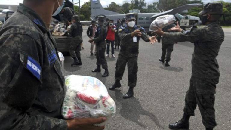Honduran Air Force members load supplies on planes, to be taken to residents of Puerto Lempira municipality, department of Gracias a Dios, in preparation for the arrival of the upcoming Hurricane Eta, in Tegucigalpa, on November 2, 2020. (Photo by Orlando SIERRA / AFP)