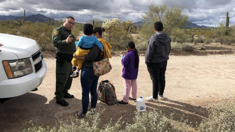 Un agente de la patrulla fronteriza habla con una inmigrante hondureña junto a sus tres hijos en la frontera de Arizona.