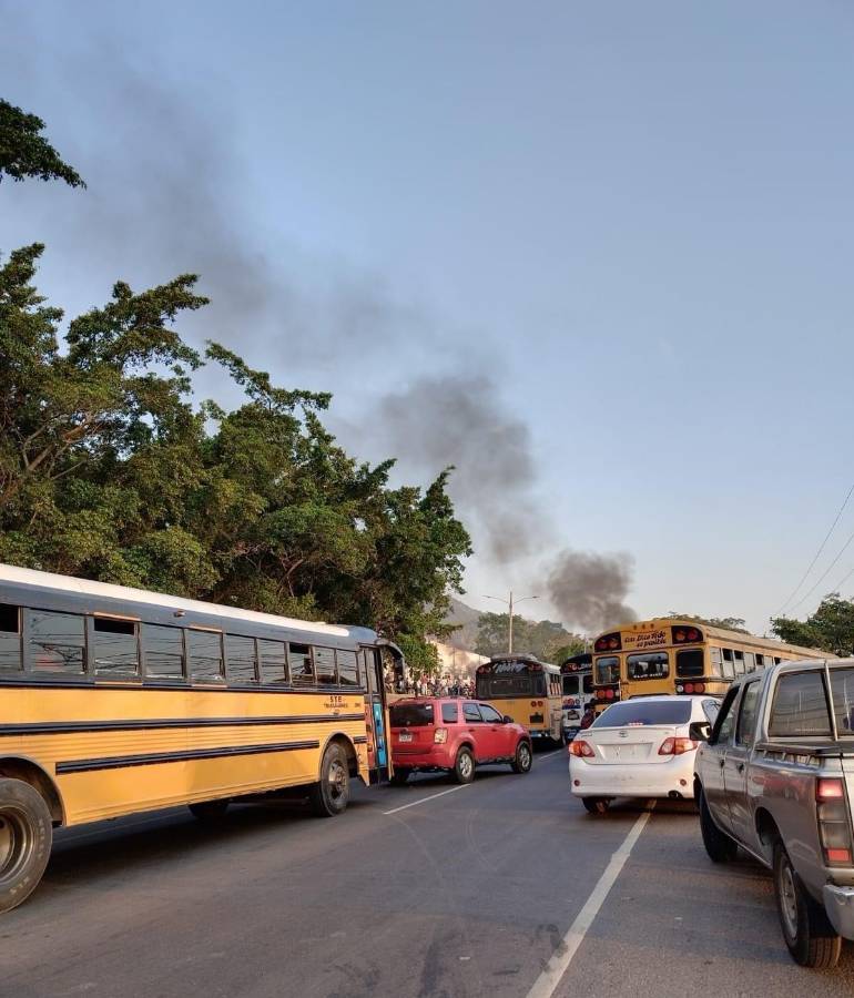 Vehículos particulares y autobuses están varados en la zona de la protesta ante el bloqueo de ambos carriles de la CA-5, en Villanueva, Cortés.