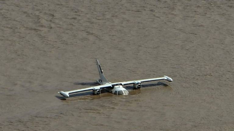Avión parcialmente sumergido vista cerca de la base aérea Armando Escalón Espinal en el municipio de La Lima, en las afueras de San Pedro Sula. AFP