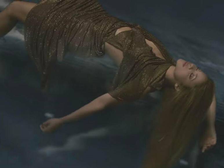 En otra escena se ve a la cantante cayendo al abismo con un vestido de brillos color dorado.