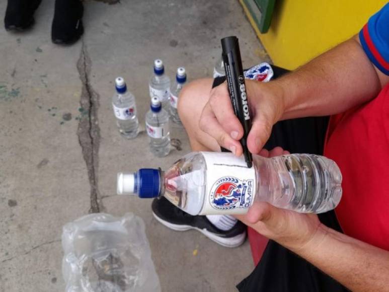El utilero del Olimpia marcando las botellas de agua con el número de cada jugador.