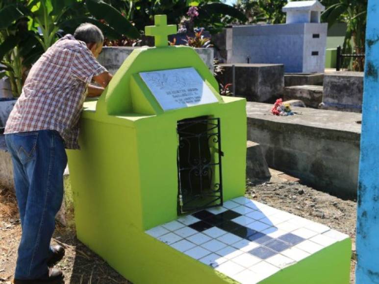 Un hombre limpia una tumba en el Cementerio Central de San Pedro Sula con motivo de la conmemoración del Día de los Muertos.