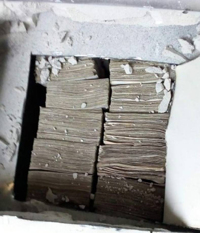 En una pared de tabla yeso estaba escondido gran parte del dinero en lempiras.