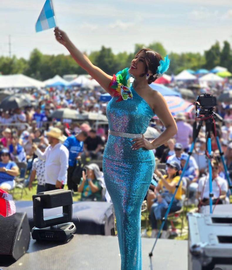 Su vestido en color azul turqueza delínea su esbelta figura y en una de los lados de los hombros los acompañó con plumas simulando nuestra ave nacional, La Guacamaya.