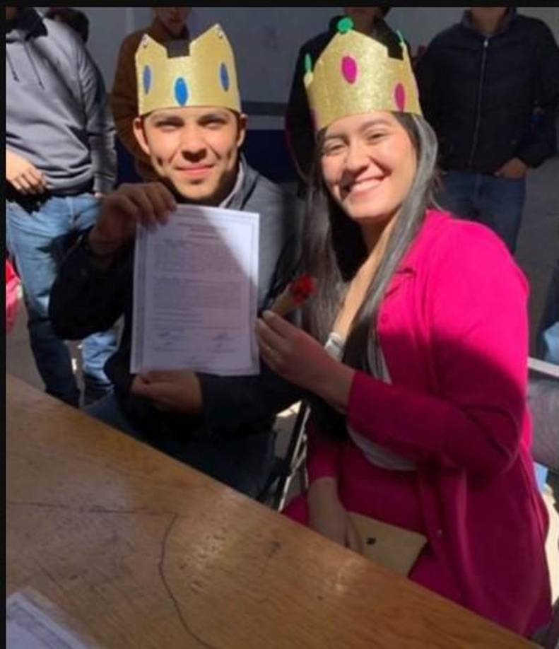 Los “novios” muestran el acta de matrimonio a los asistentes.