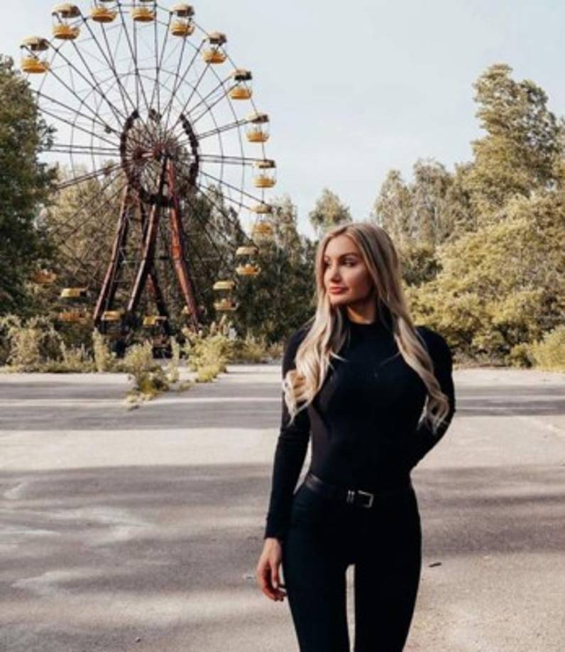 Tourists examine souvenirs in the stall on the checkpoint of a 30-kilometer (19-mile) Chernobyl exclusion zone around the plant on August 1, 2019. - The hit US drama 'Chernobyl' brought a new generation of tourists to the nuclear disaster zone, but guides say many visitors are more interested in taking selfies or even stealing artefacts than learning about the accident. (Photo by Genya SAVILOV / AFP)